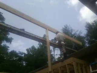 Carpenter setting a ridge beam over a new addition frame — Ice Dam Removal by Roofing Brothers in Green Valley