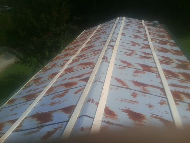 Rusted metal roof panels with new wood purlins before replacement — Storm Damage Roof Repair in Green Valley by Roofing Brothers