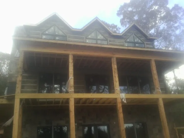 Dormers and porch framing on a large log home under construction — Roof Coating work by our crew in Green Valley
