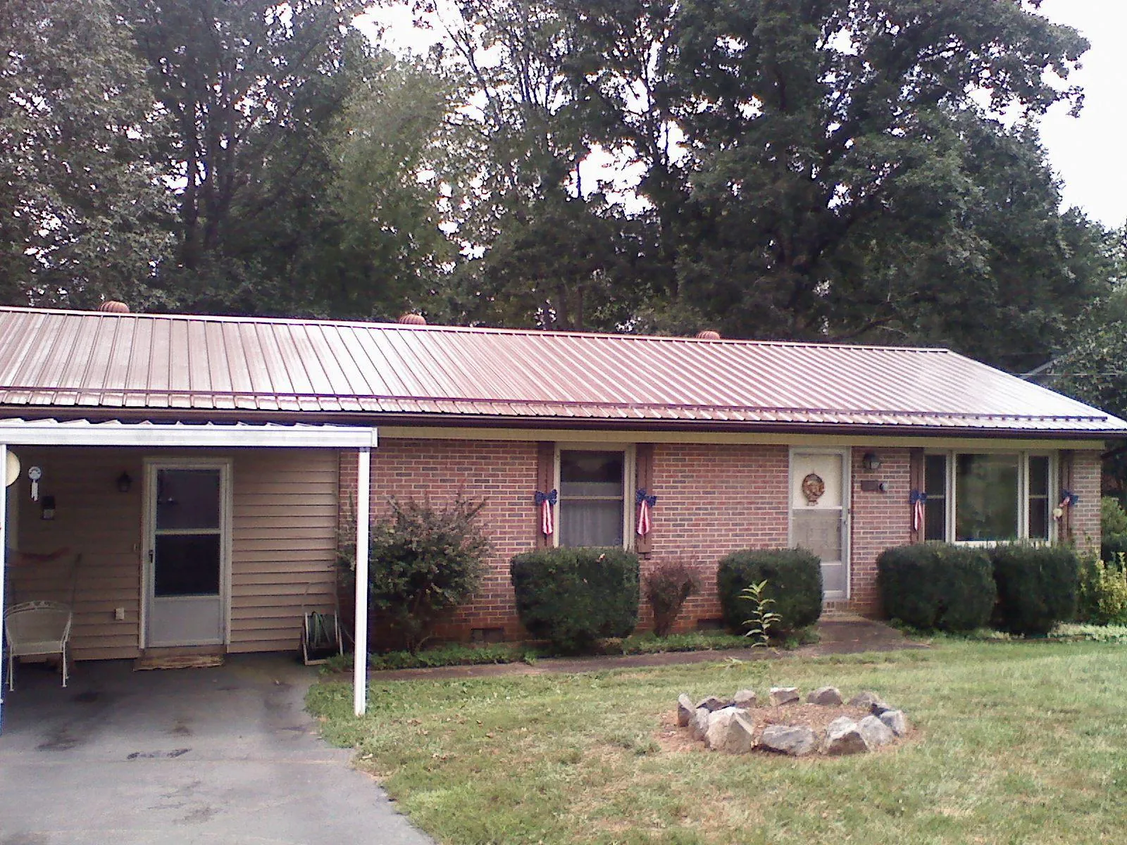 Bronze metal roof and carport on a brick ranch home — Roof Repair work by our crew in Green Valley
