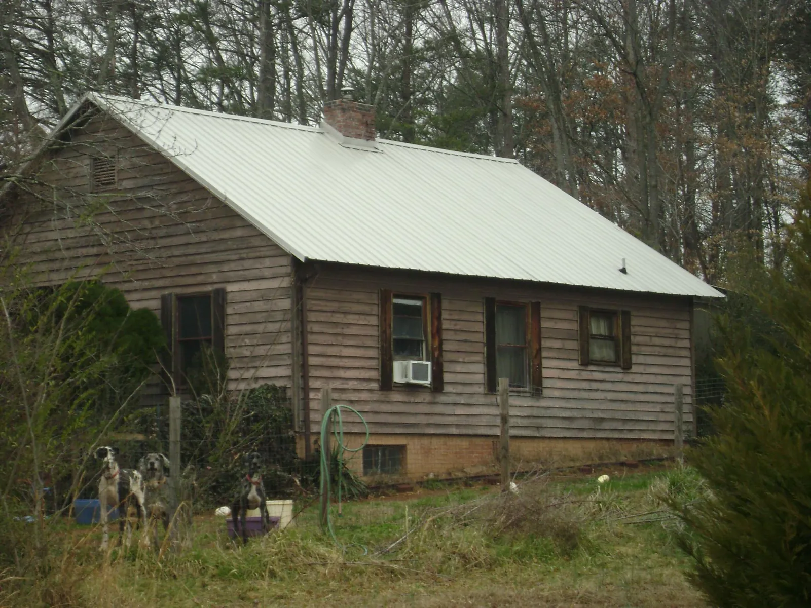 White metal roof on an old wood sided farmhouse, from a Metal Roof Installation job in Green Valley